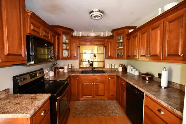 a kitchen with stainless steel appliances granite countertop sink stove top oven and cabinets