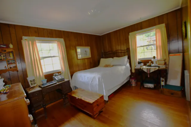 a bedroom with a bed and wooden floor