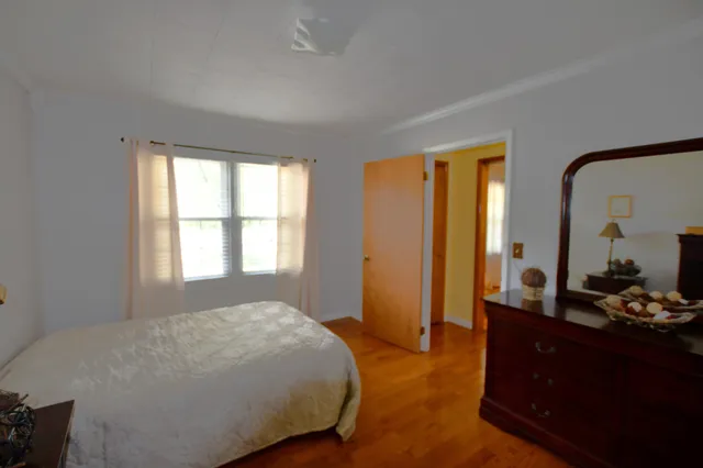 a bedroom with a bed and large windows