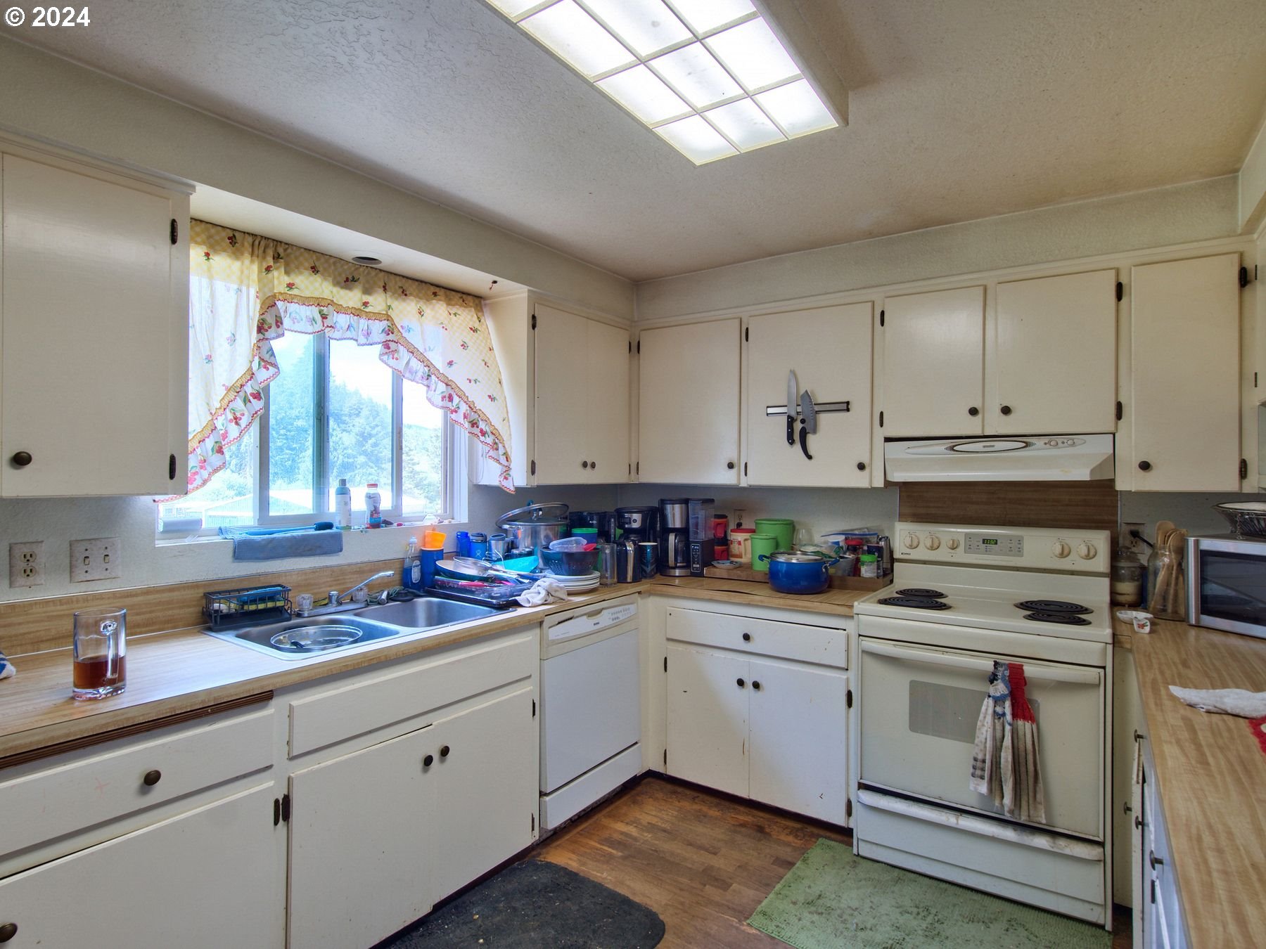 28250 Andy Riggs Road Grand Ronde, OR 97347 - Photo 37 of 48 a kitchen with cabinets appliances a sink and a window