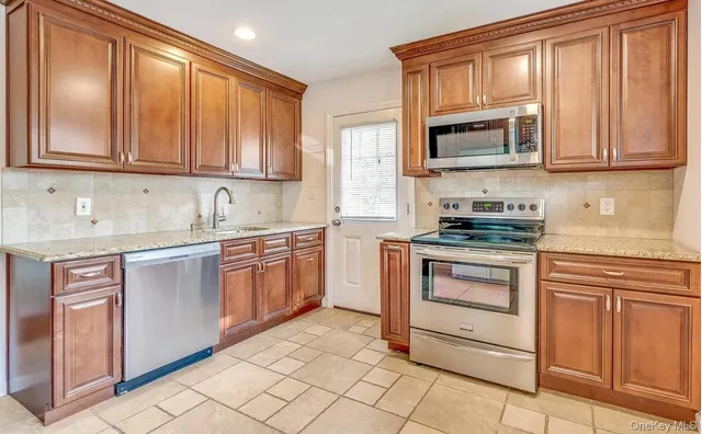 a kitchen with stainless steel appliances granite countertop a stove microwave and cabinets