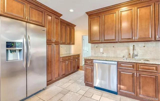 a kitchen with stainless steel appliances granite countertop a refrigerator and cabinets