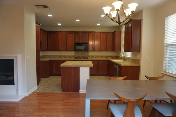 a kitchen with kitchen island granite countertop a sink cabinets and window