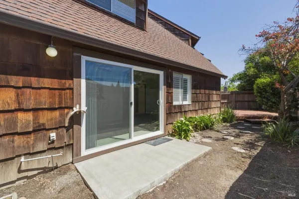 a view of backyard with wooden fence and potted plants