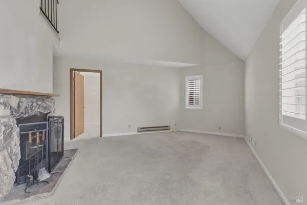 a view of an empty room with a fireplace and a window