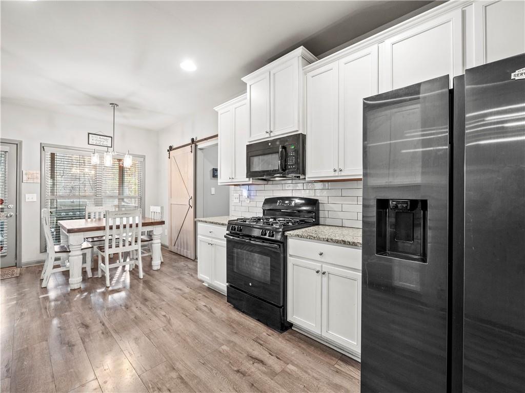 816 Mimosa Way Jefferson, GA 30549 - Photo 16 of 43 a kitchen with stainless steel appliances a stove top oven a refrigerator a dining table and chairs