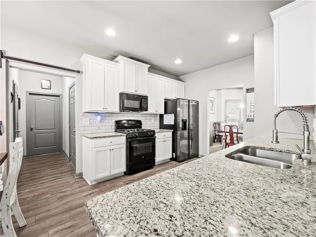 a kitchen with stainless steel appliances granite countertop a refrigerator sink and stove