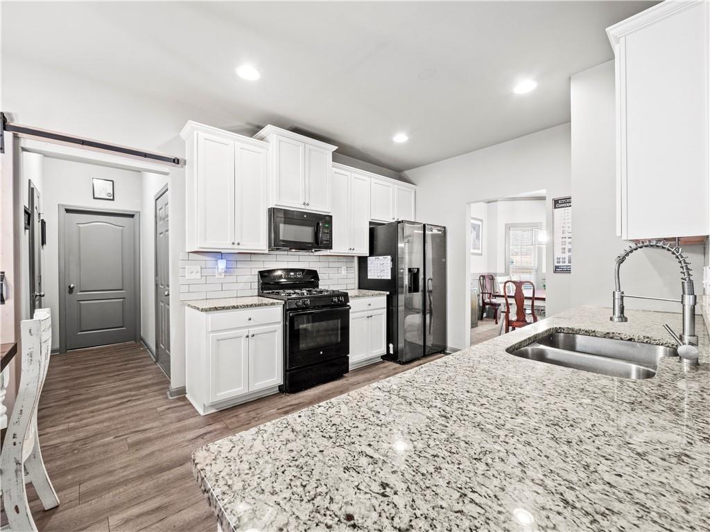 816 Mimosa Way Jefferson, GA 30549 - Photo 17 of 43 a kitchen with stainless steel appliances granite countertop a refrigerator sink and stove