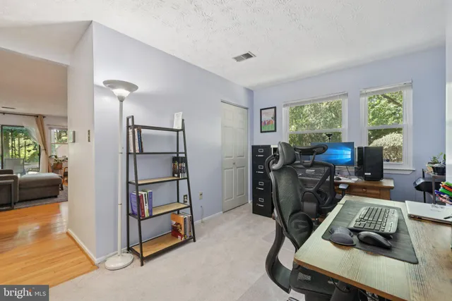 a view of a workspace with furniture and a window