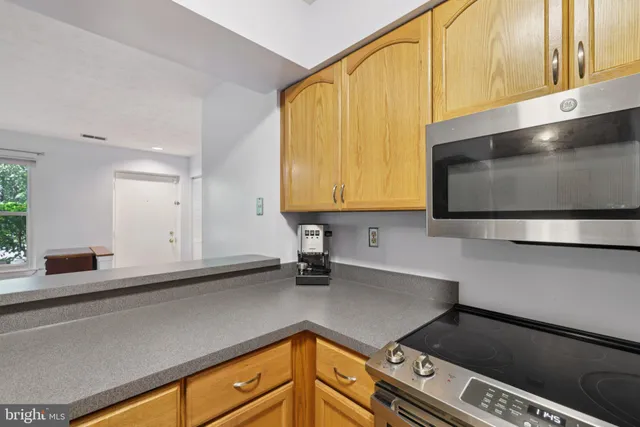 a view of a workspace with furniture and a window