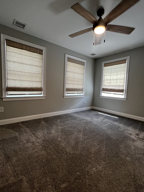 181 Christina Street, Unit 1 Newton, MA 02461 - Photo 12 of 24 an empty room with chandelier fan and windows