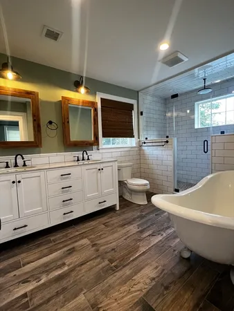 a spacious bathroom with a large mirror a bathtub and a sink