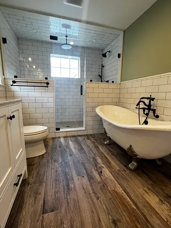 a bathroom with a sink a toilet and shower