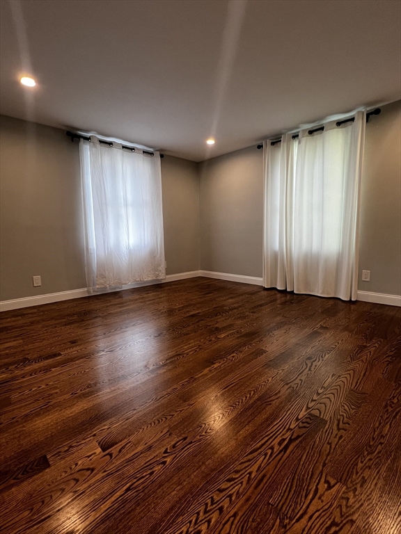 181 Christina Street, Unit 1 Newton, MA 02461 - Photo 9 of 24 an empty room with wooden floor and windows