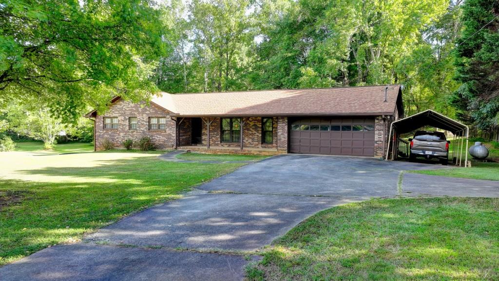 5680 Abbotts Bridge Road Johns Creek, GA 30097 - Photo 1 of 63 a front view of a house with a yard and garage