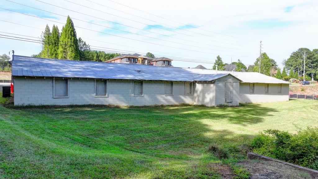 5680 Abbotts Bridge Road Johns Creek, GA 30097 - Photo 18 of 63 a view of a wooden house with a yard plants and large tree