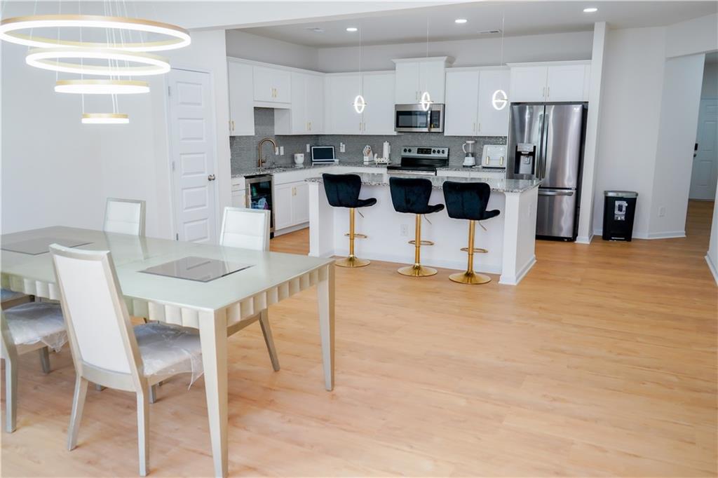 2115 Ravencliff Drive Austell, GA 30168 - Photo 5 of 21 a living room with stainless steel appliances kitchen island granite countertop a dining table chairs and a refrigerator