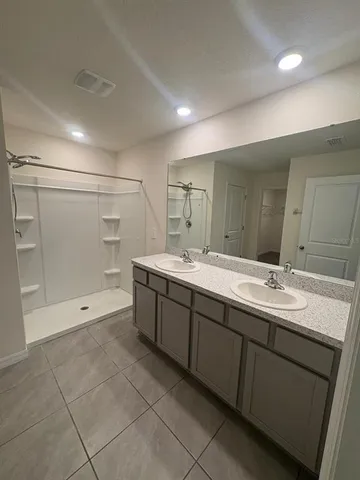 a bathroom with a granite countertop sink mirror and shower