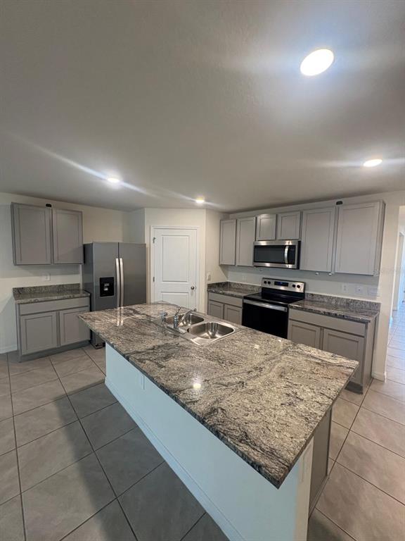 6910 Southeast 112th Street Belleview, FL 34420 - Photo 9 of 20 a kitchen with stainless steel appliances granite countertop a sink stove and refrigerator