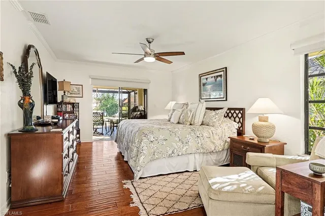 a spacious bedroom with a bed a couch and wooden floor