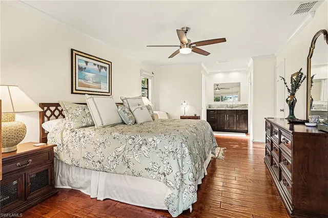 a spacious bedroom with a bed and wooden floor