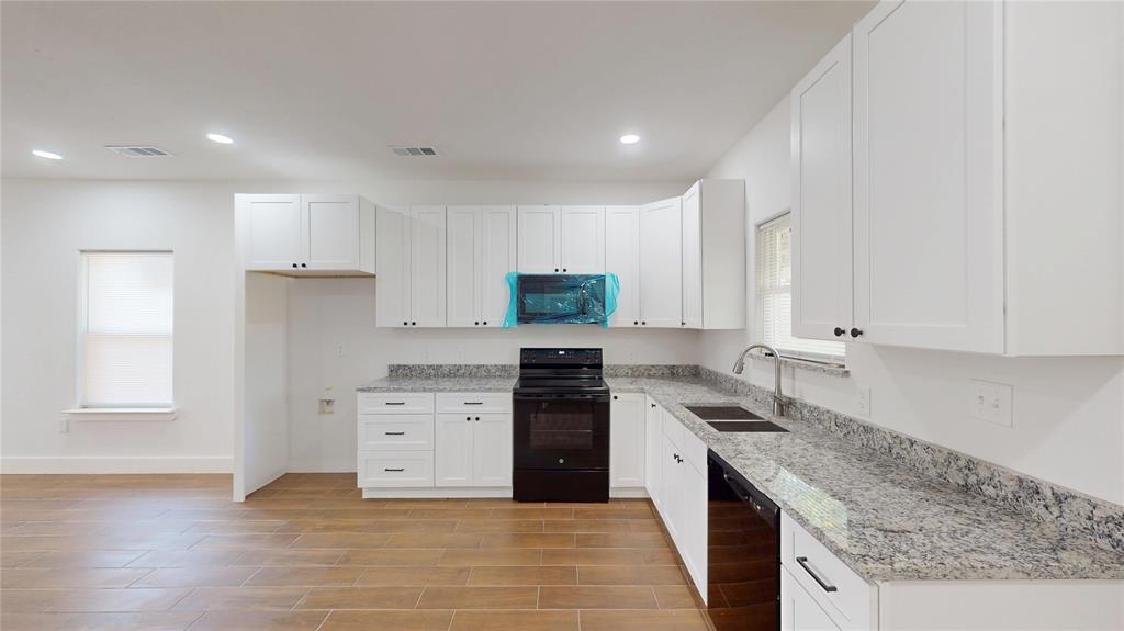 1615 Poplar Street Dallas, TX 75215 - Photo 11 of 31 a kitchen with granite countertop a stove top oven sink and cabinets