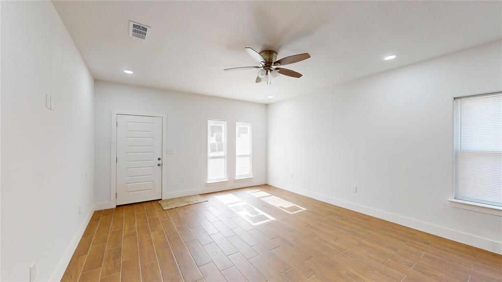 1615 Poplar Street Dallas, TX 75215 - Photo 5 of 31 an empty room with wooden floor fan and windows