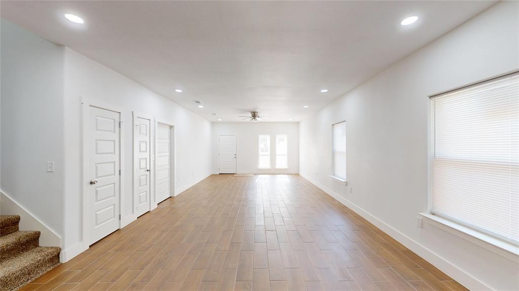 1615 Poplar Street Dallas, TX 75215 - Photo 6 of 31 a view of an empty room with wooden floor and a window