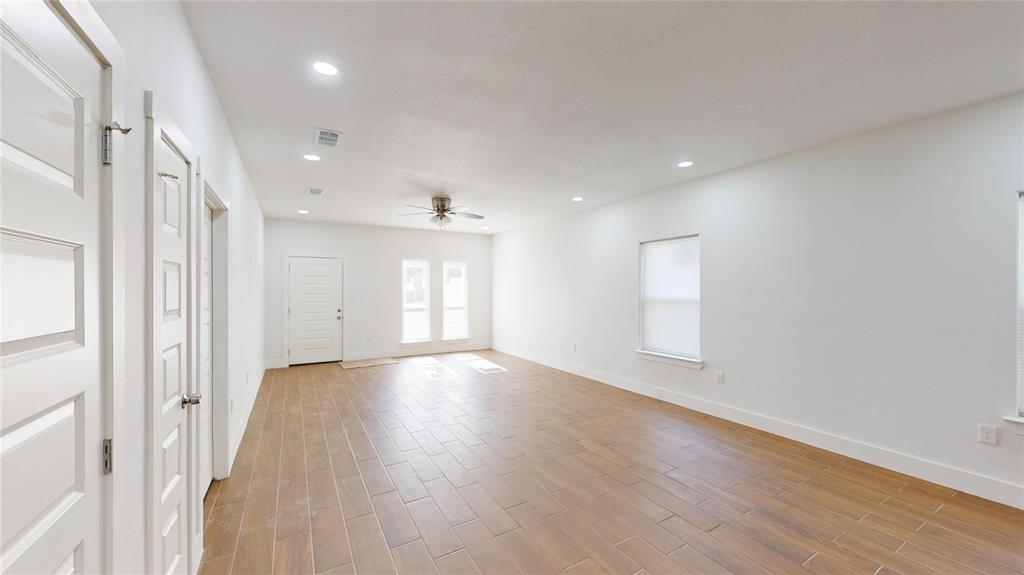 1615 Poplar Street Dallas, TX 75215 - Photo 7 of 31 a view of an empty room with wooden floor and a window