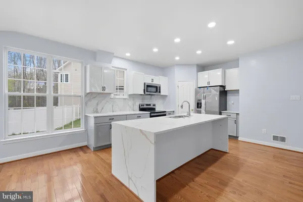 a kitchen with a sink cabinets and wooden floor