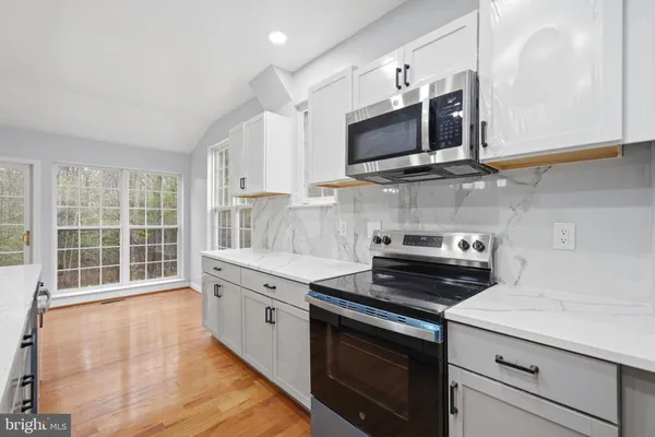 a kitchen with stainless steel appliances a stove microwave and sink