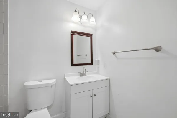 a bathroom with a toilet a sink and mirror