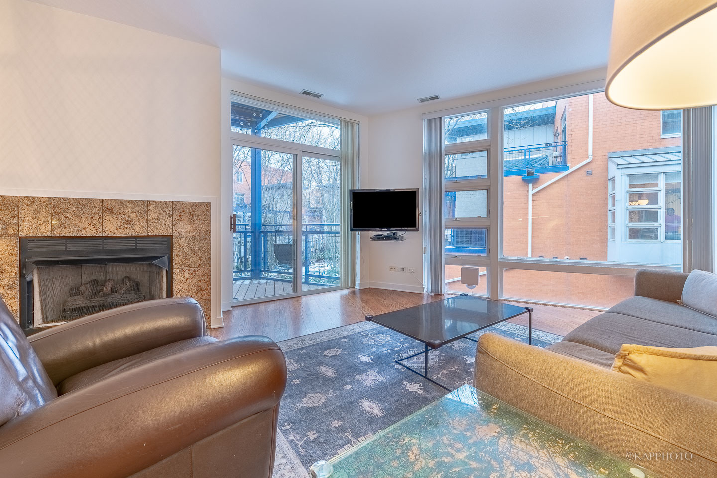 1151 West Washington Boulevard, Unit 125 Chicago, IL 60607 - Photo 14 of 24 a living room with furniture a flat screen tv and a fireplace