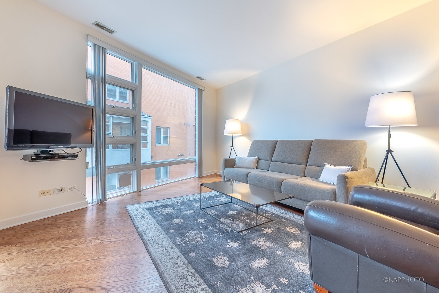 1151 West Washington Boulevard, Unit 125 Chicago, IL 60607 - Photo 15 of 24 a living room with furniture and a flat screen tv