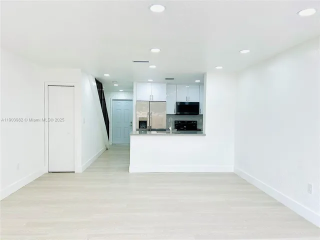 a view of a kitchen with a sink and a refrigerator