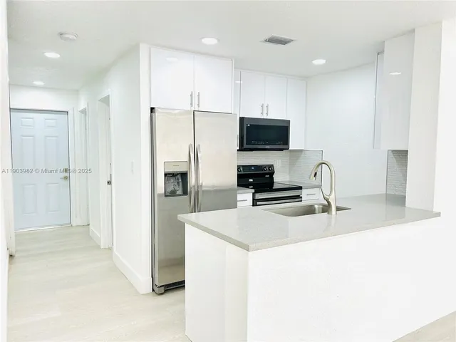 a kitchen with stainless steel appliances a refrigerator and a sink