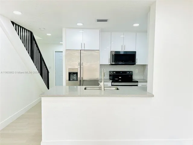 a kitchen with stainless steel appliances a refrigerator and a stove top oven