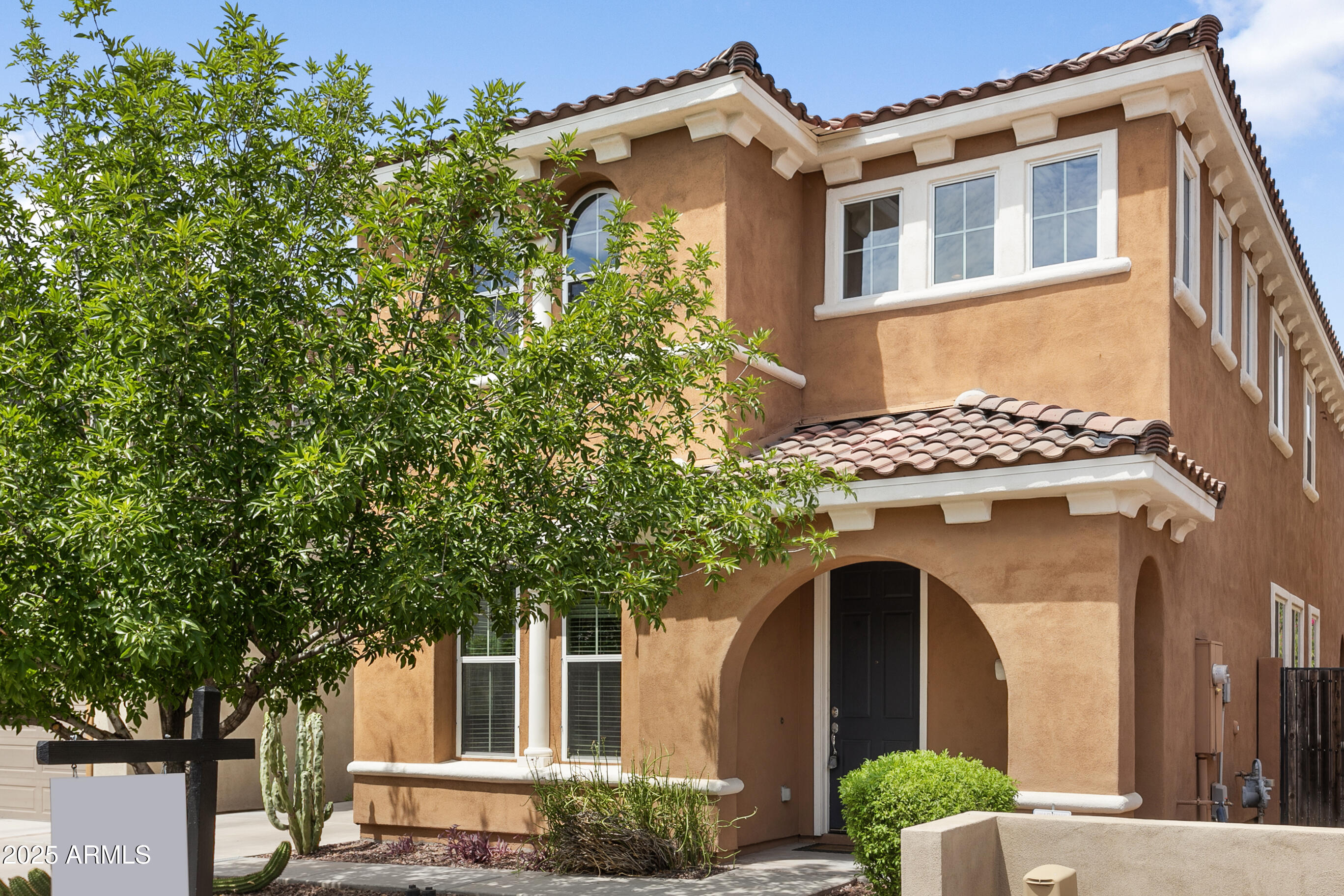 a front view of a house with a tree
