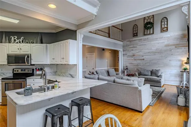 a living room with couches and a fireplace with wooden floor