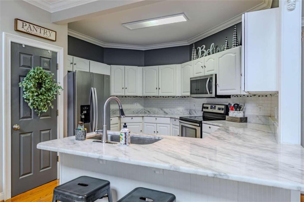26 Saddlebrook Drive Rome, GA 30161 - Photo 22 of 63 a kitchen with stainless steel appliances a sink a stove a refrigerator cabinets and a counter top space