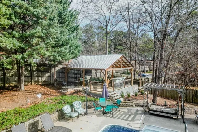 a view of a patio with table and chairs potted plants and large tree