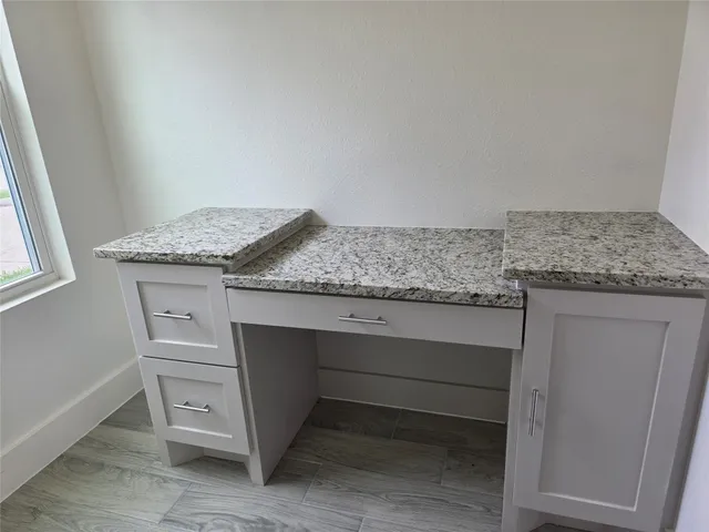 a kitchen with granite countertop cabinets appliances and a counter space