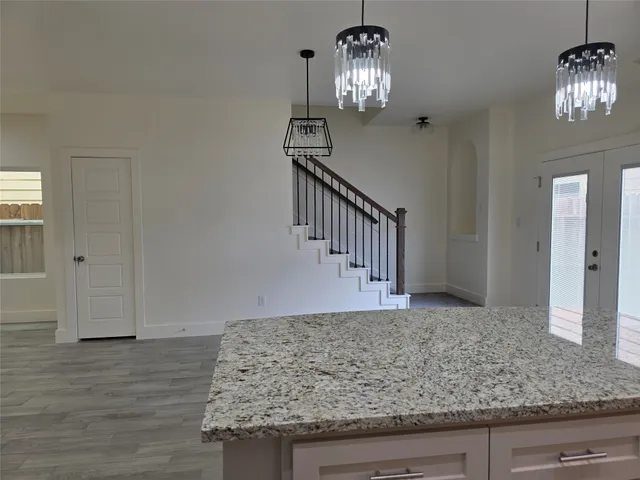a view of a livingroom with wooden floor and stairs