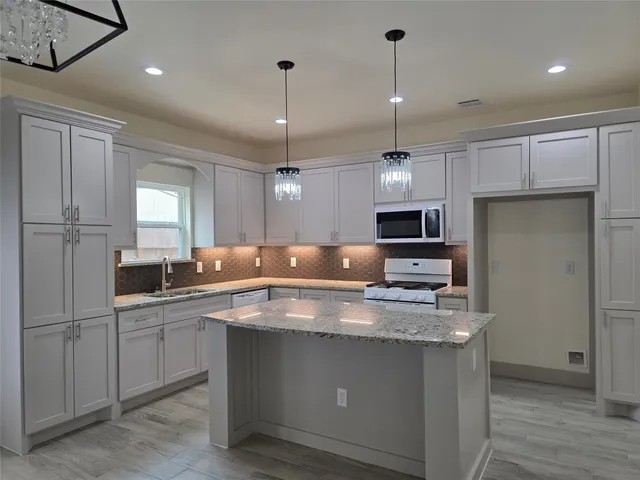 a kitchen with kitchen island a sink stainless steel appliances and window