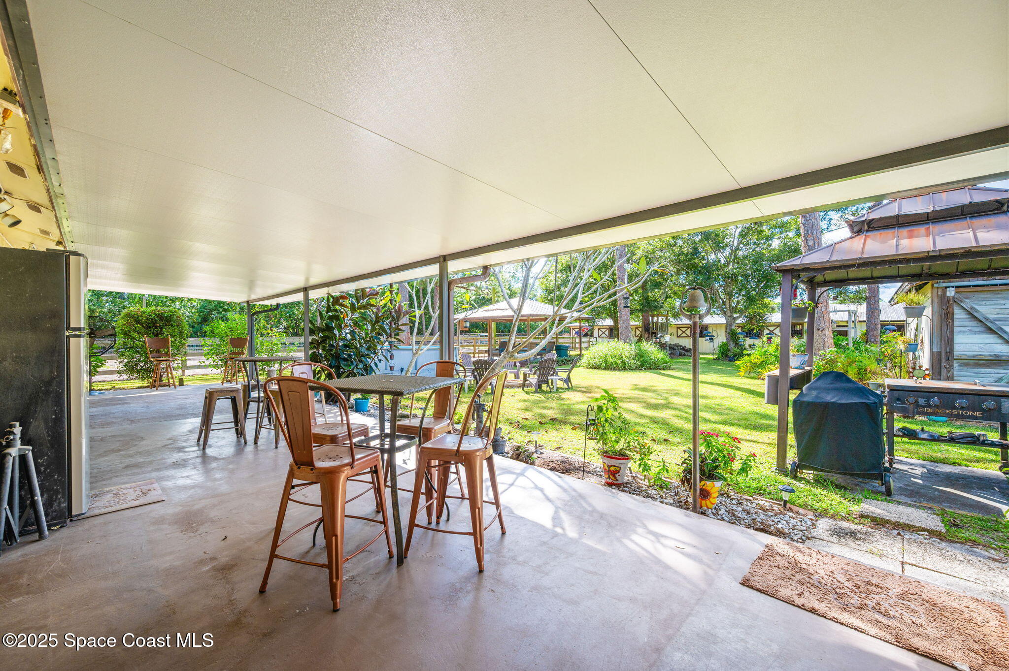 4505 Eldorado Way Melbourne, FL 32934 - Photo 42 of 78 a view of a patio with a table chairs and a porch