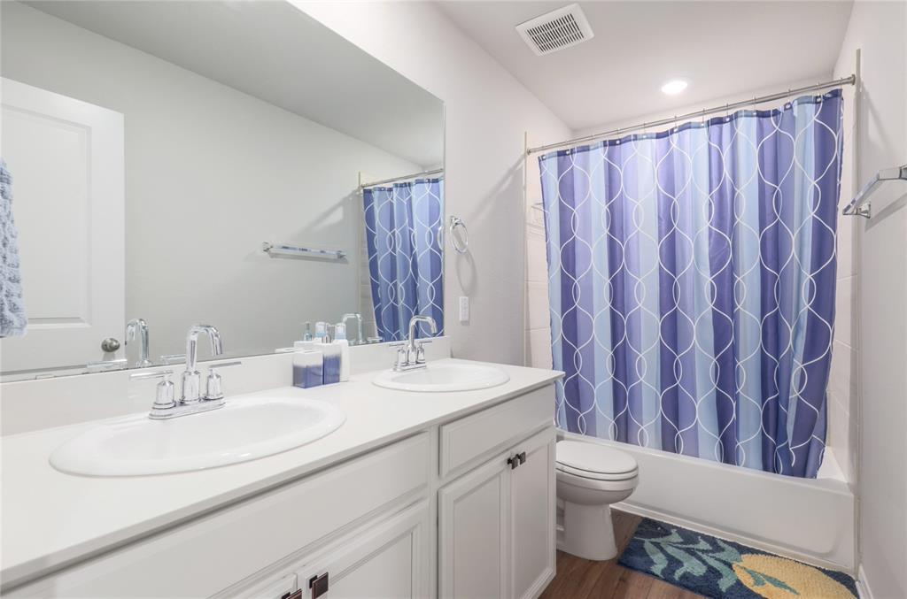 2815 Haystack Lane Round Rock, TX 78665 - Photo 25 of 30 Full bath featuring double vanity, dark wood-style floors, and shower / bath combination with curtain