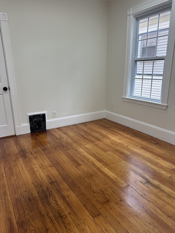 10 Dalrymple Street, Unit 2 Boston, MA 02130 - Photo 6 of 13 an empty room with wooden floor and windows