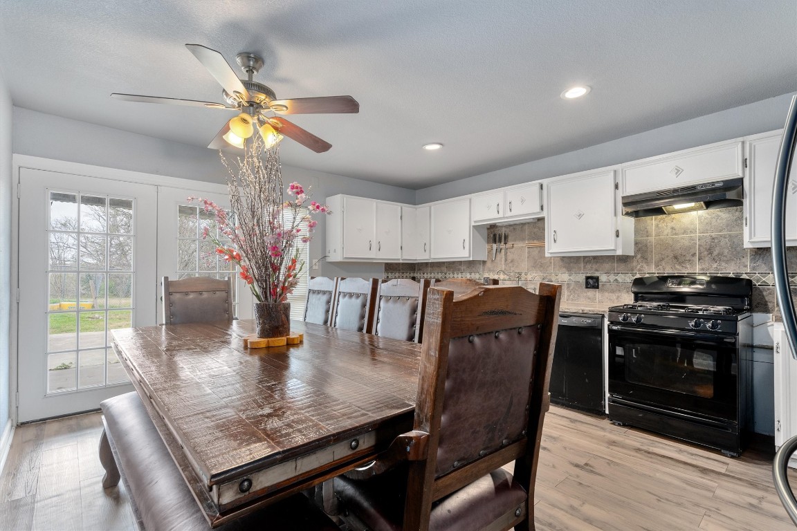2203 Windy Hill Road Kyle, TX 78640 - Photo 12 of 29 a kitchen with stainless steel appliances granite countertop a stove top oven a sink a dining table and chairs