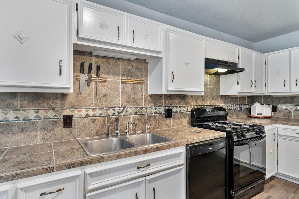 2203 Windy Hill Road Kyle, TX 78640 - Photo 15 of 29 a kitchen with stainless steel appliances granite countertop a sink a stove and cabinets