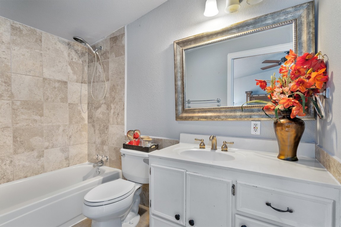 2203 Windy Hill Road Kyle, TX 78640 - Photo 20 of 29 a bathroom with a sink toilet mirror and shower